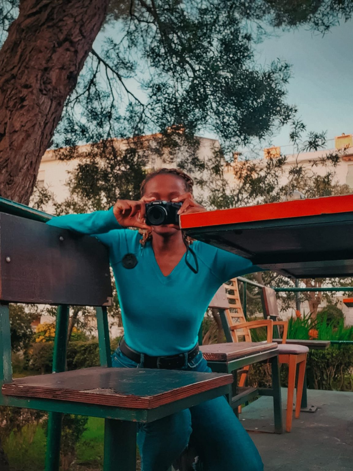 woman taking a photo in the park. she is holding her camera