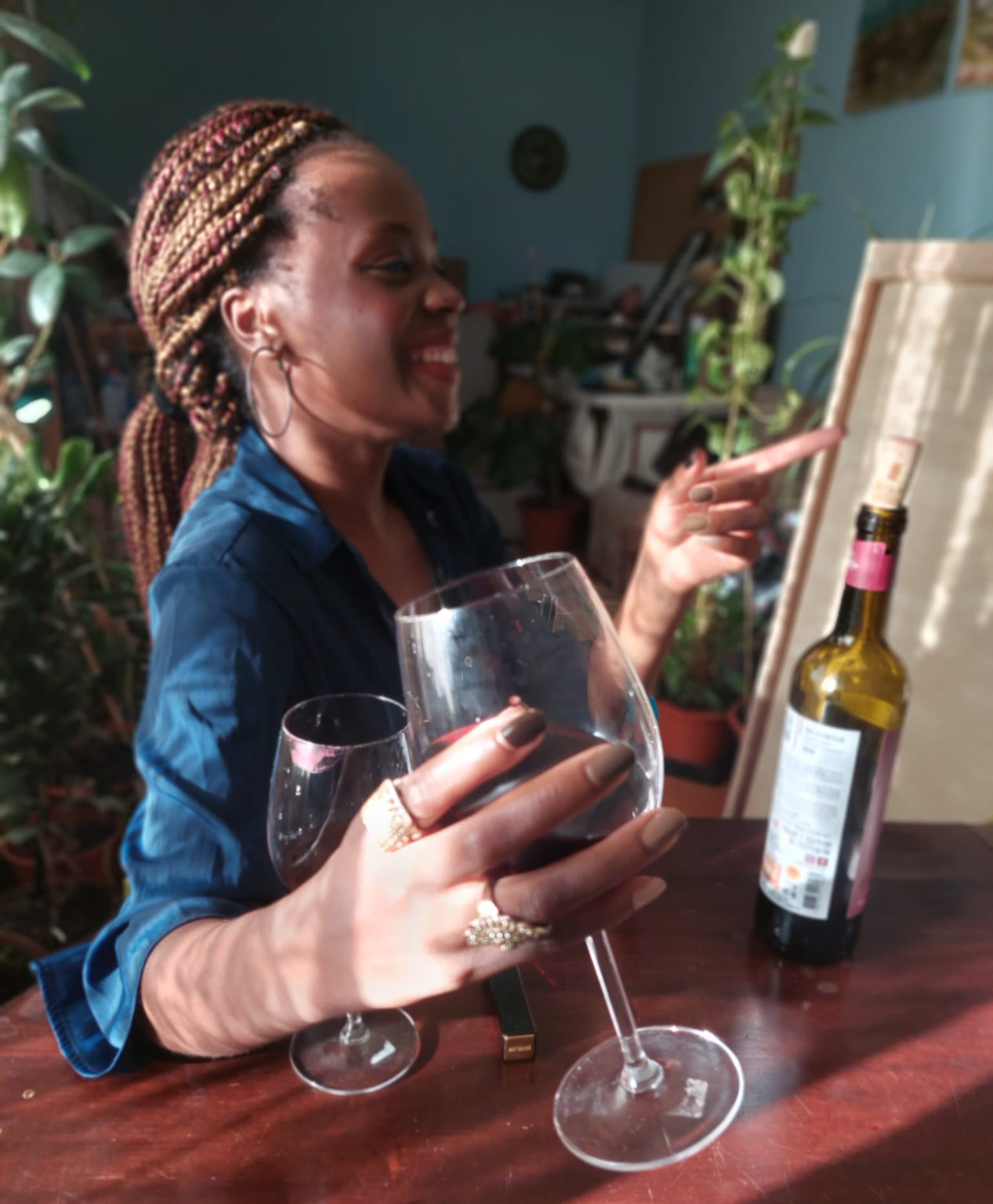 woman is holding a wine glass while laughing